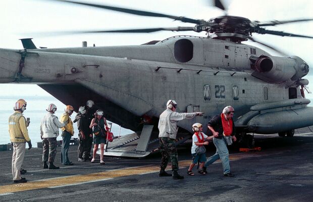 Image: Evacuees from Freetown, Sierra Leone, cross the flight deck of the USS Kearsarge.